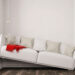 Schief positioniertes Sofa in kleinem Raum mit weißer Wand – kein Kleiderschrank mit Spiegel vorhanden