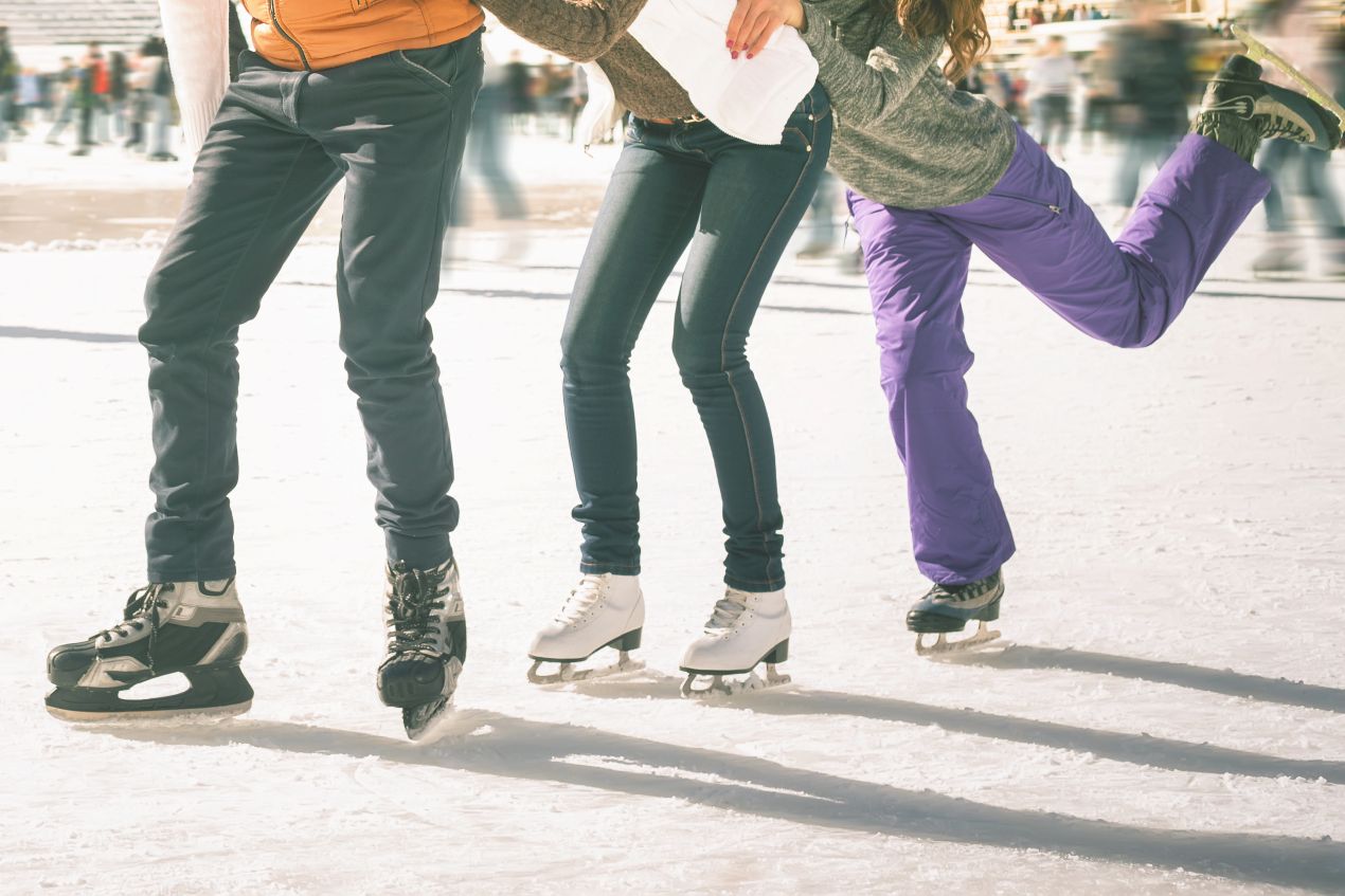Drei Personen auf Outdoor-Eisbahn tragen verschiedene Modelle der Schlittschuhe Bauer