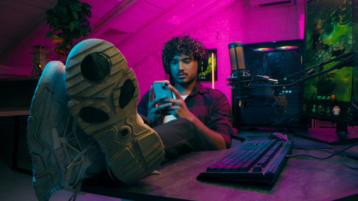 Gamer mit Smartphone vor PC-Setup | Vape